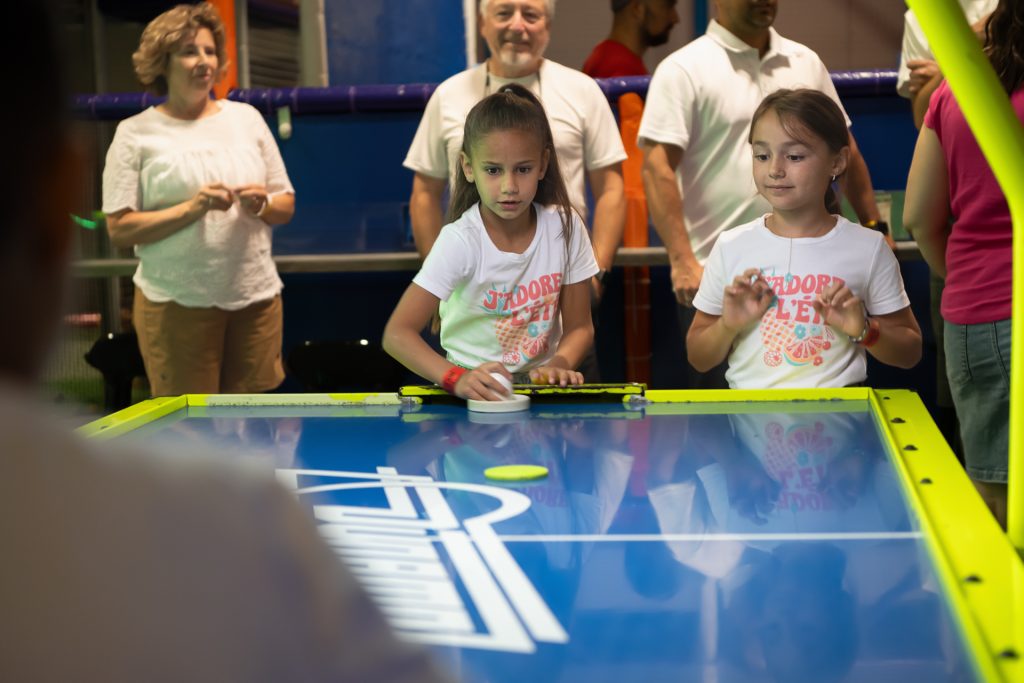 Enfants d'anniversaire s'amusant aux arcades sous le regard des parents