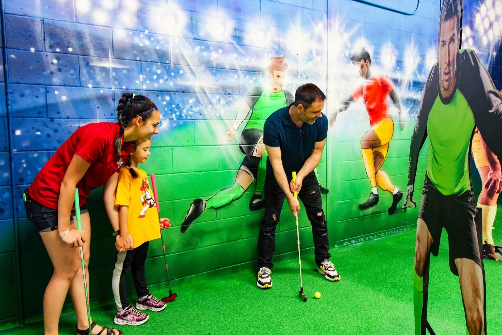 Famille jouant au mini-golf fluo