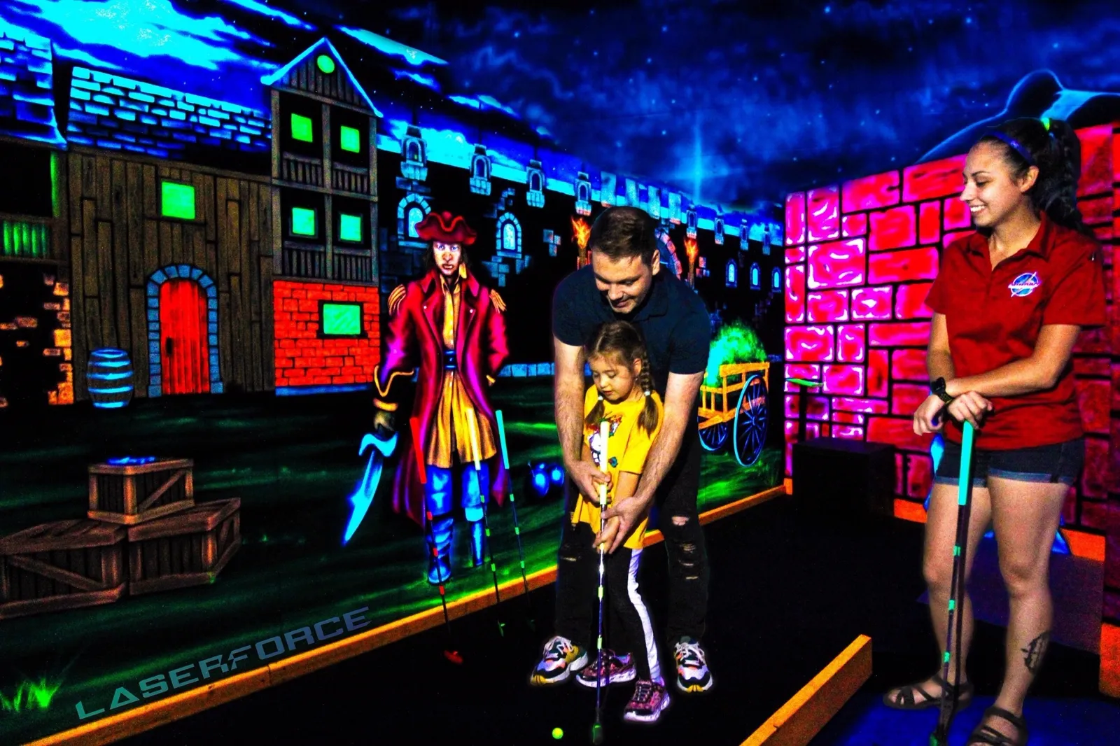 Famille jouant au mini-golf fluo