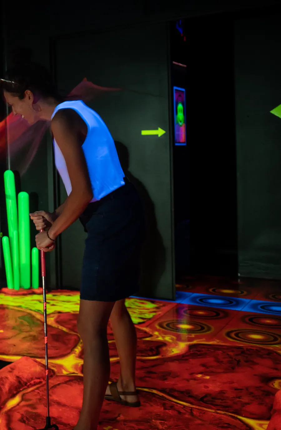 Adulte qui joue au mini-golf fluo lors d'une sortie en couple à Drummondville