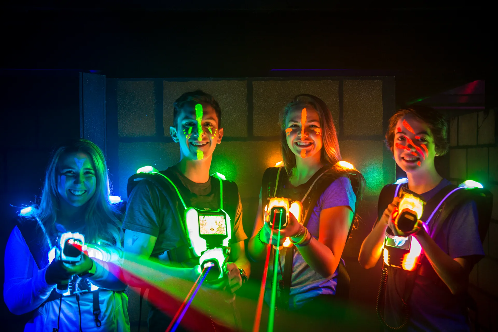 Groupe d'amis souriants avec leur équipement de laser tag